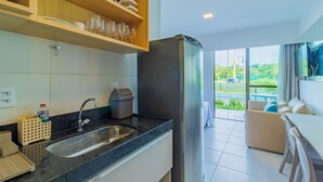 Una cocina moderna con un lavamanos empotrado, un refrigerador y estantes de madera sobre la encimera.