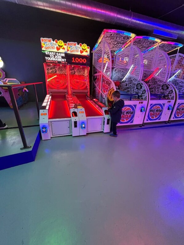 A gaming arcade with neon lights and a prize display.