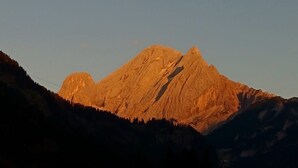 Una montaña con un edificio en primer plano.