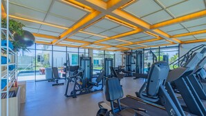 A modern gym with various exercise equipment, large windows, and a wooden ceiling. - Cais Eco #304 - Apartment With Pool by Carpediem (Ipojuca)