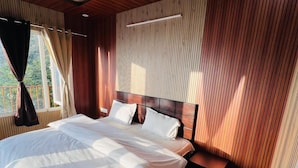 Ein Zimmer mit einem großen Bett, Holzvertäfelung und Blick auf Grün.