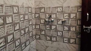 Ein Duschbereich mit einer Fliesenwand mit geometrischem Muster.