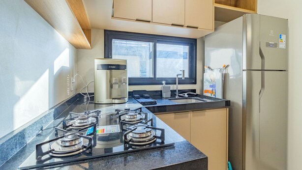 A modern kitchen with a gas stove, a coffee maker, and a refrigerator. - Cais Eco #212 - Apartment on the Sand by Carpediem (Ipojuca)