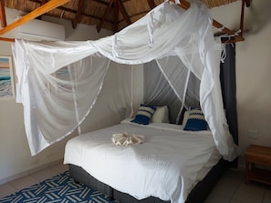 Ein Bett mit einem weißen Baldachin und einem blau gemusterten Teppich.