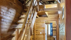 Un interior de madera con una escalera que sube a un segundo piso.
