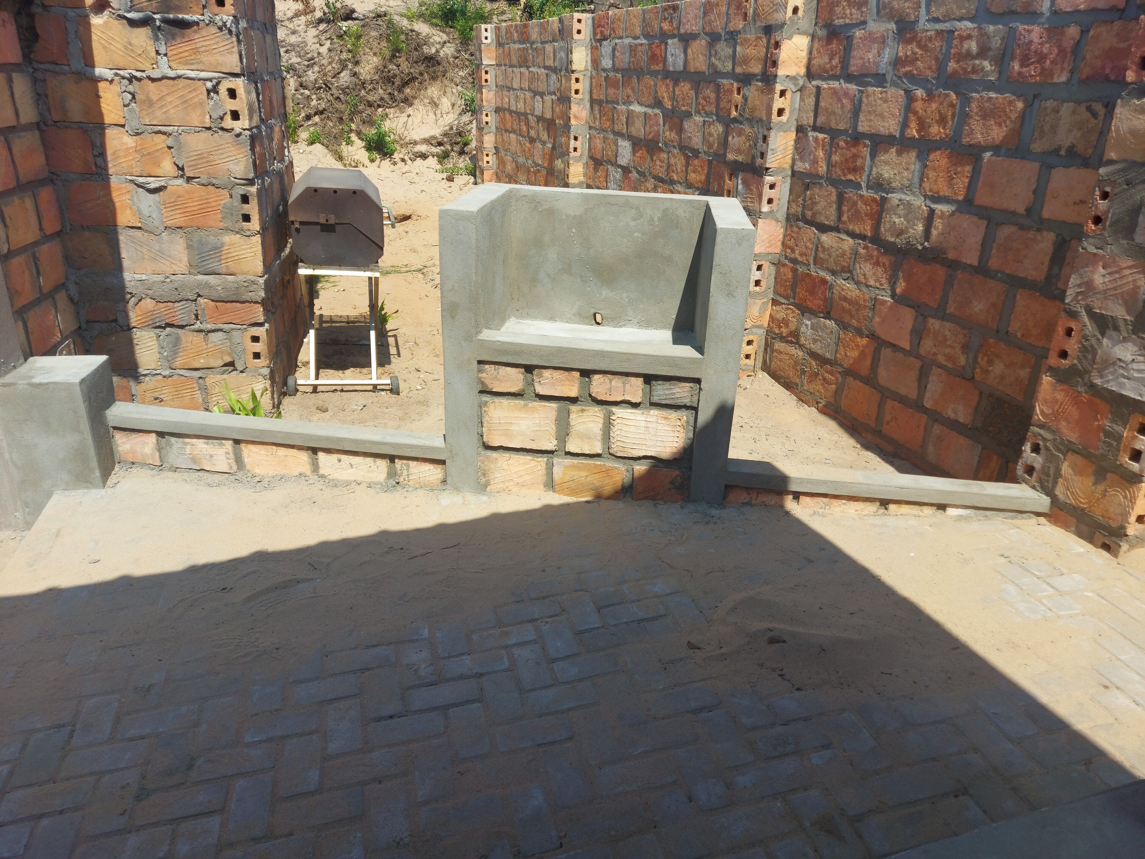 Un mur de briques avec un banc en béton au premier plan.