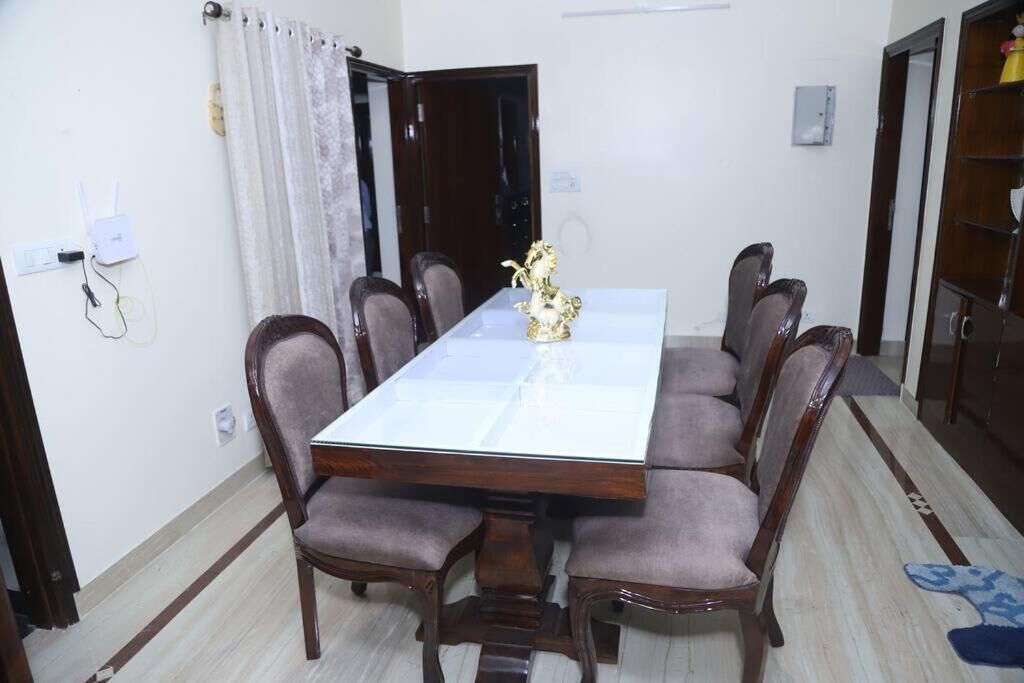 Un comedor con una mesa rectangular, seis sillas y un jarrón decorativo.