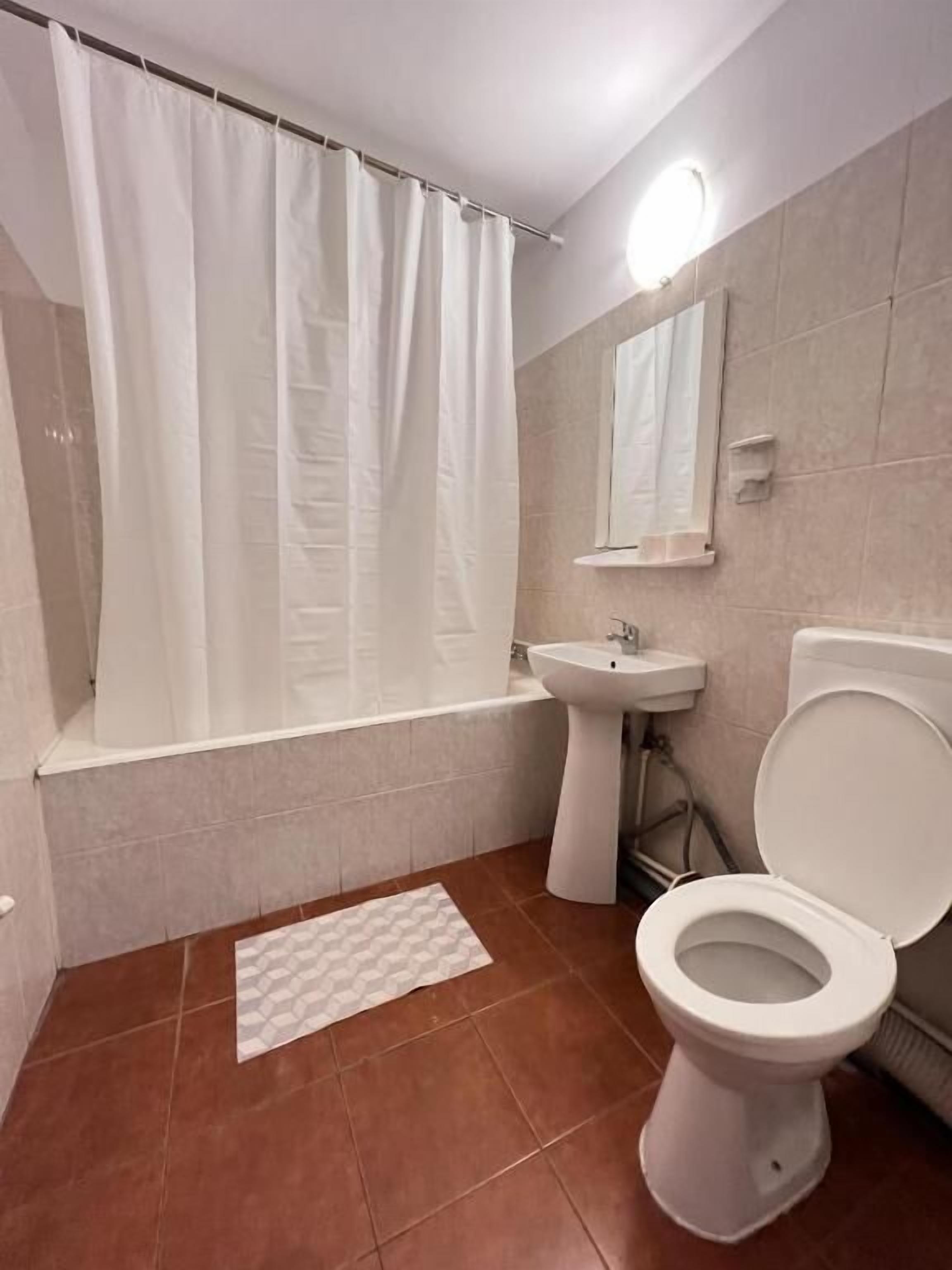 Ein Badezimmer mit Badewanne, Waschbecken, Toilette und Duschvorhang.