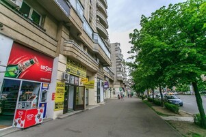 Una calle con una fila de comercios, incluyendo una tienda 'URSOUS' visible y varios letreros que indican 'EXCHANGE'.
