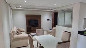 En moderne stue med sofa, spisebord og stole.