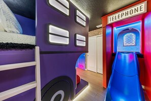 A children's play area with a slide, a bed, and a telephone-themed wall. - 5BR w Pool Grill Game Lounge Indoor Slide 16165 (Clermont)