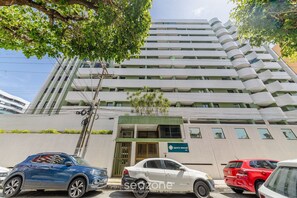 Ένα πολυώροφο κτίριο με μοντέρνο σχεδιασμό, το οποίο διαθέτει μια επιβλητική εί σοδο με μια πράσινη τέντα και μια επιγραφή που αναγράφει «Monte Berrone 516».