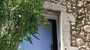 A stone building with a blue door and a set of stone steps leading to it. - Domaine les Mejeonnes (Valaurie)
