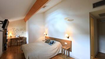 A bedroom with a bed, bedside tables, a desk, and a chair.