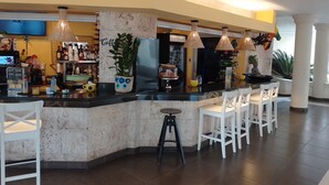 Uma área de bar com balcão, banquetes e geladeira.