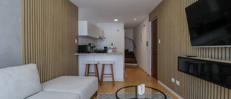 A modern apartment with a living room, kitchen, and dining area.
