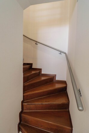 A wooden staircase with a metal handrail, leading to an upper floor. - w Deluxe 1BR Duplex in the Heart of Barranco (Lima)