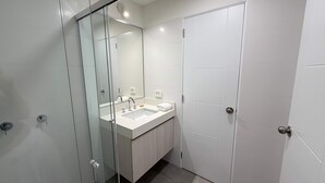 A modern bathroom with a glass shower enclosure, a sink, and a white vanity. - w Amazing and Cozy 2BR w Balcony in Miraflores (Lima)