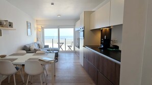 Eine moderne Küche mit Essbereich, einer Couch und Meerblick.