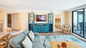 A living room with a sofa, coffee table, TV, and entertainment unit. - SUMMER SPECIAL RATES!!!  2B/2B NEWLY REMODELED BEACHFRONT CORNER CONDO AT SHAMRON BEACH CLUB 308! POOL! (Fort Myers Beach)