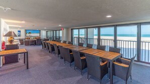 A spacious room with a long wooden table and wicker chairs, large windows with a view of the beach, and a small kitchenette area. - SUMMER SPECIAL RATES!!!  2B/2B NEWLY REMODELED BEACHFRONT CORNER CONDO AT SHAMRON BEACH CLUB 308! POOL! (Fort Myers Beach)