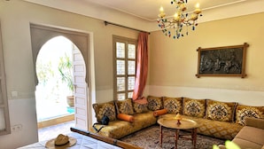 Una habitación con cama, sofá, una mesita y un candelabro.