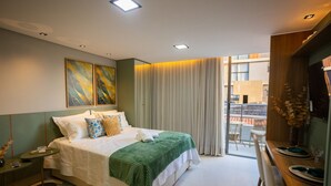 Ein modernes Schlafzimmer mit einem großen Bett, einem Esstisch mit Stühlen und einem Balkon mit Aussicht.