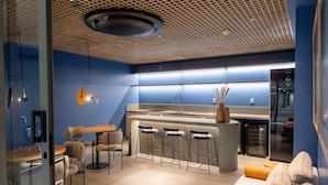 Eine moderne Küche mit Bar, Barhocker und einer Sitzecke mit Sofa und Sesseln.