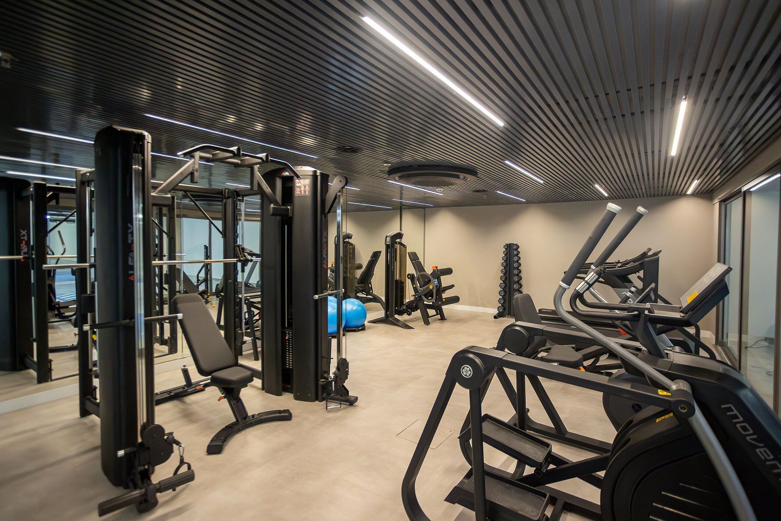 A modern gym with various exercise equipment, including treadmills and weight machines.