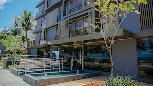 A modern building with a pool, outdoor seating, and a palm tree. - Unity #423 - Elegance by the sea by Carpediem (João Pessoa)