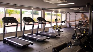 Ein Fitnessraum mit Laufbändern, Crosstrainern und Krafttrainingsgeräten.