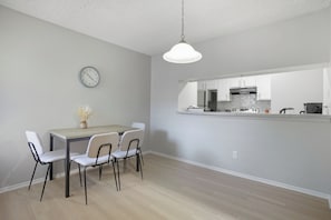 A modern kitchen with white cabinets, a stainless steel range hood, and a countertop with a coffee maker. - Spacious 2 bed 2 bath getaway (San Antonio)