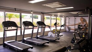 A gym with treadmills, an elliptical, and weight machines. - Puerto Ventura #303 - Flat by the sea in Carpediem (João Pessoa)