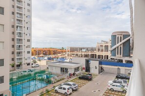 A residential building with a basketball court, parking area, and a view of the surrounding neighborhood. - Mirante #401 - Comfortable Apartment by Carpediem (Fortaleza)