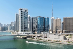 A cityscape with modern skyscrapers, including a prominent building with "DAMAC" signage. - Stayshort - Stunning 1 Bed in Business Bay That Sleeps 2 With Burj Views (Dubai)