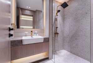 A modern bathroom with a glass-enclosed shower, a white sink, and a wooden vanity. - Stayshort - Amazing Studio in JVC That Sleeps 2 With Balcony (Dubai)