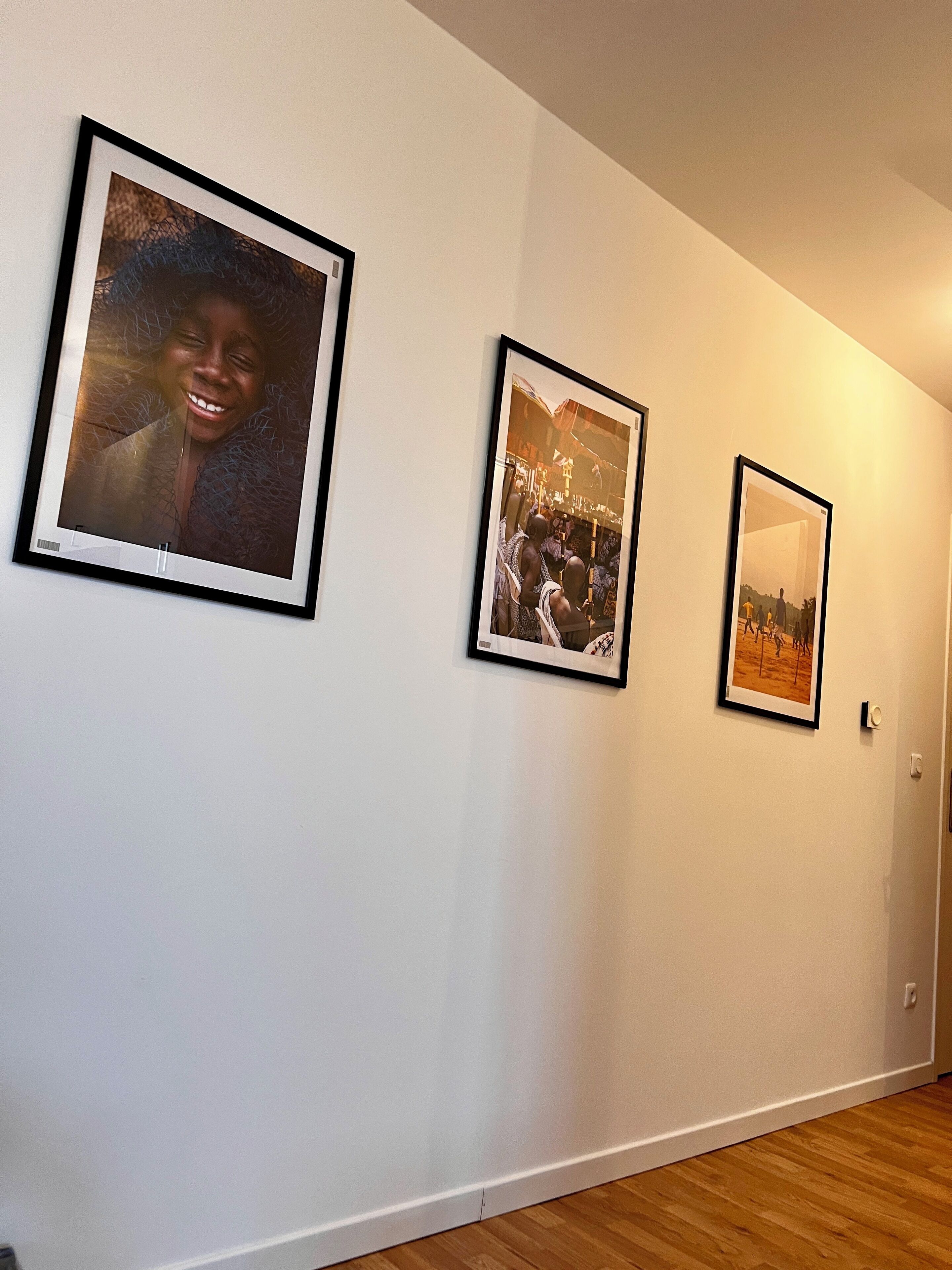 A hallway with three framed photographs on the wall.