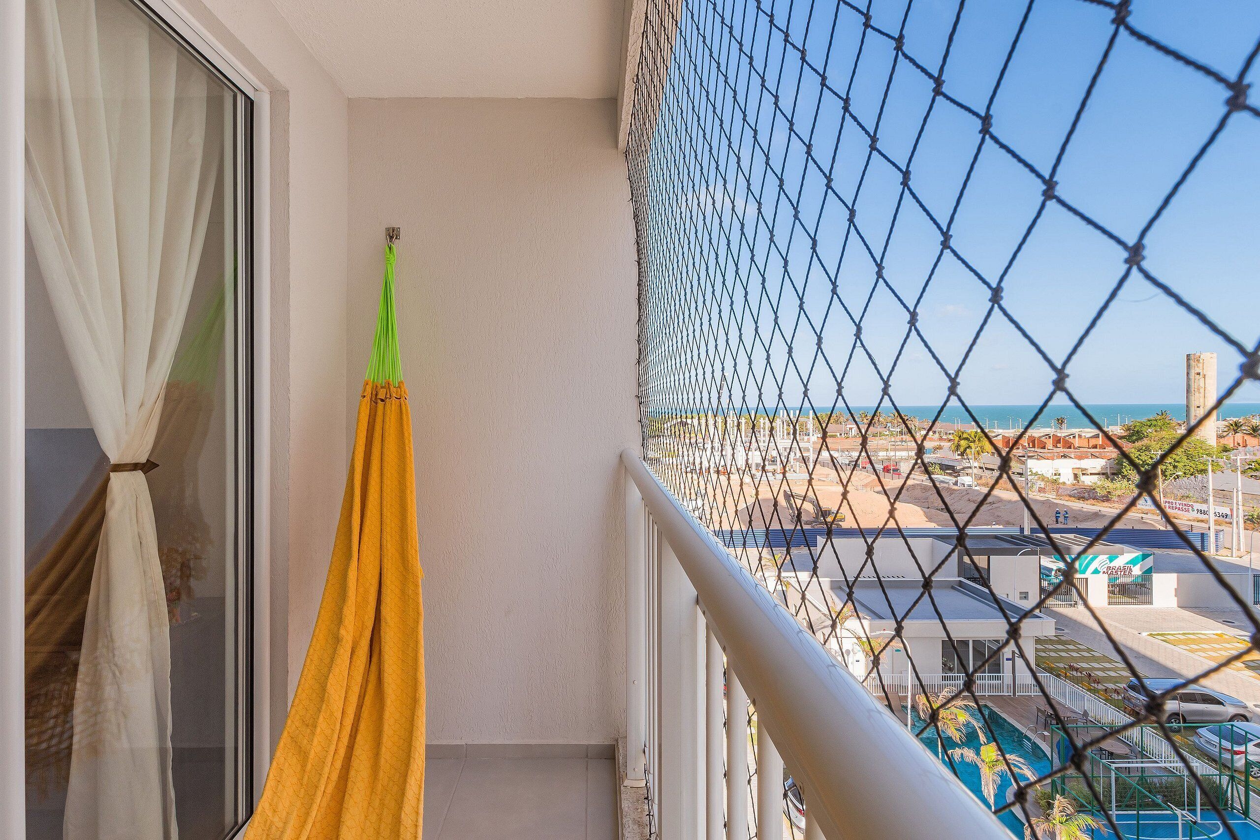 Un balcón con vistas a una piscina y un edificio con un letrero.