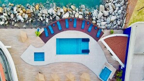 A pool area with a large central pool, smaller side pools, and lounge chairs. - Iate Plaza #1404 - Studio Vista Mar por Carpediem (Fortaleza)
