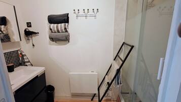 Een haardroger, handdoeken, zeep, toiletpapier