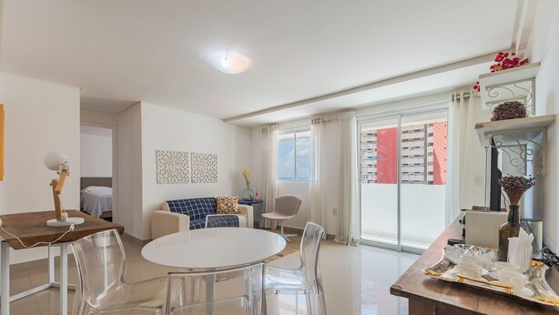 A modern living room with a dining area, large windows, and a view of the city. - Hiperion #502 - Apt in Fortaleza by Carpediem (Fortaleza)