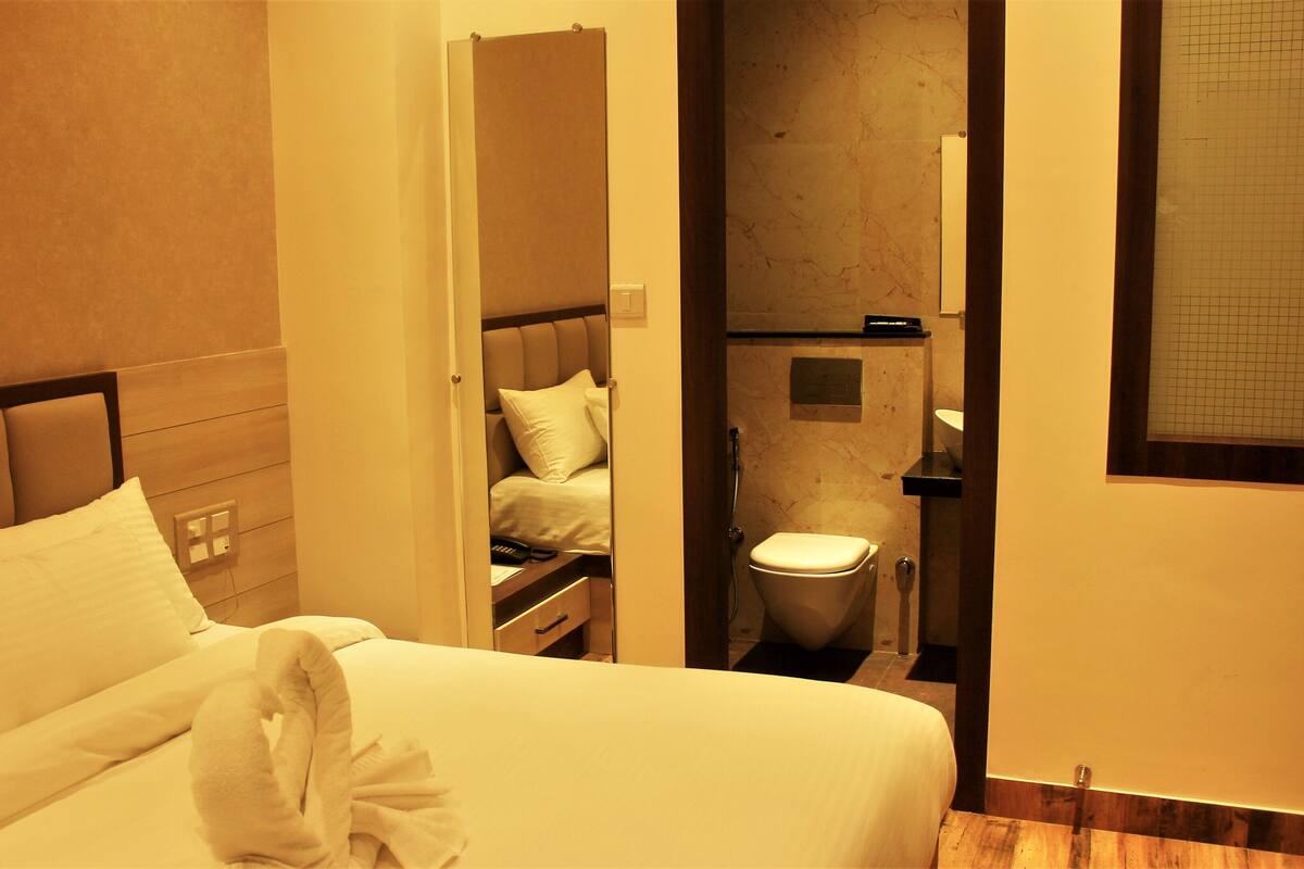 Una habitación de hotel con cama, baño y zona de ducha.