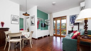 Amplia sala de estar con una mesa de comedor, sillas, un sofá y un televisor.