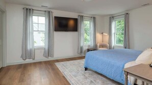 A bedroom with a bed, a TV mounted on the wall, and a bedside table. - Family-Friendly Townhouse in Wakefield with Garage (Wakefield)