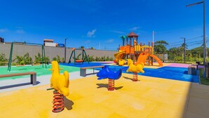 Ein Spielplatz mit Schaukeln und einer Rutsche.
