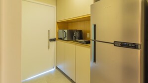 A compact kitchen with a stainless steel refrigerator, a microwave, and a coffee maker on the countertop. - Beach Class Summer #303 Ipojuca By Carpediem (Ipojuca)