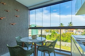 A balcony with a table and chairs, a view of the city, and a textured wall. - Beach Class Summer #303 Ipojuca By Carpediem (Ipojuca)