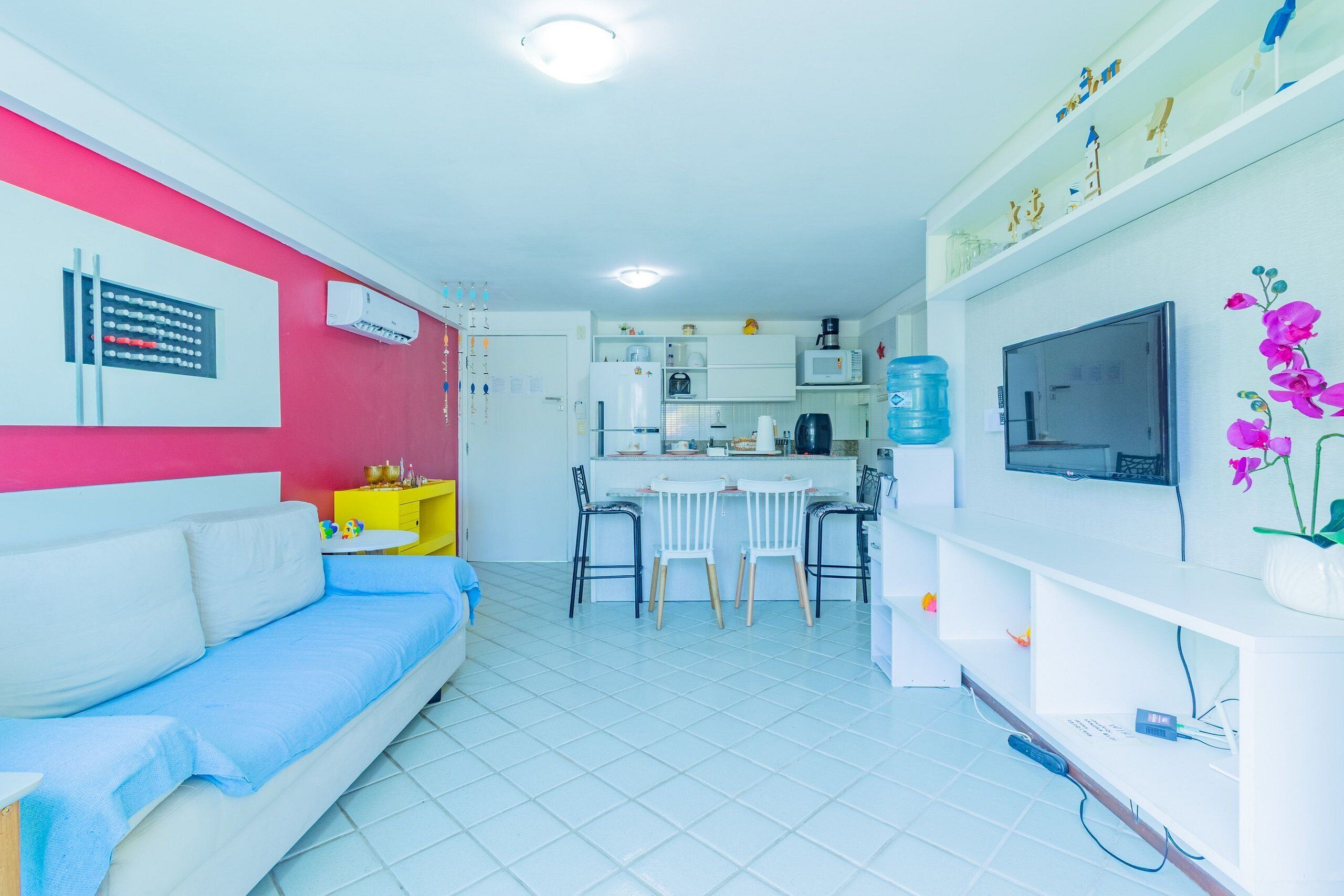 Un espacio habitable compacto con kitchenette, comedor y sofá.