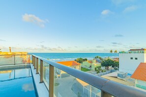 A rooftop infinity pool with a view of the ocean and surrounding buildings. - Ora Beach #306 - Studio With Balcony by Carpediem (Ipojuca)