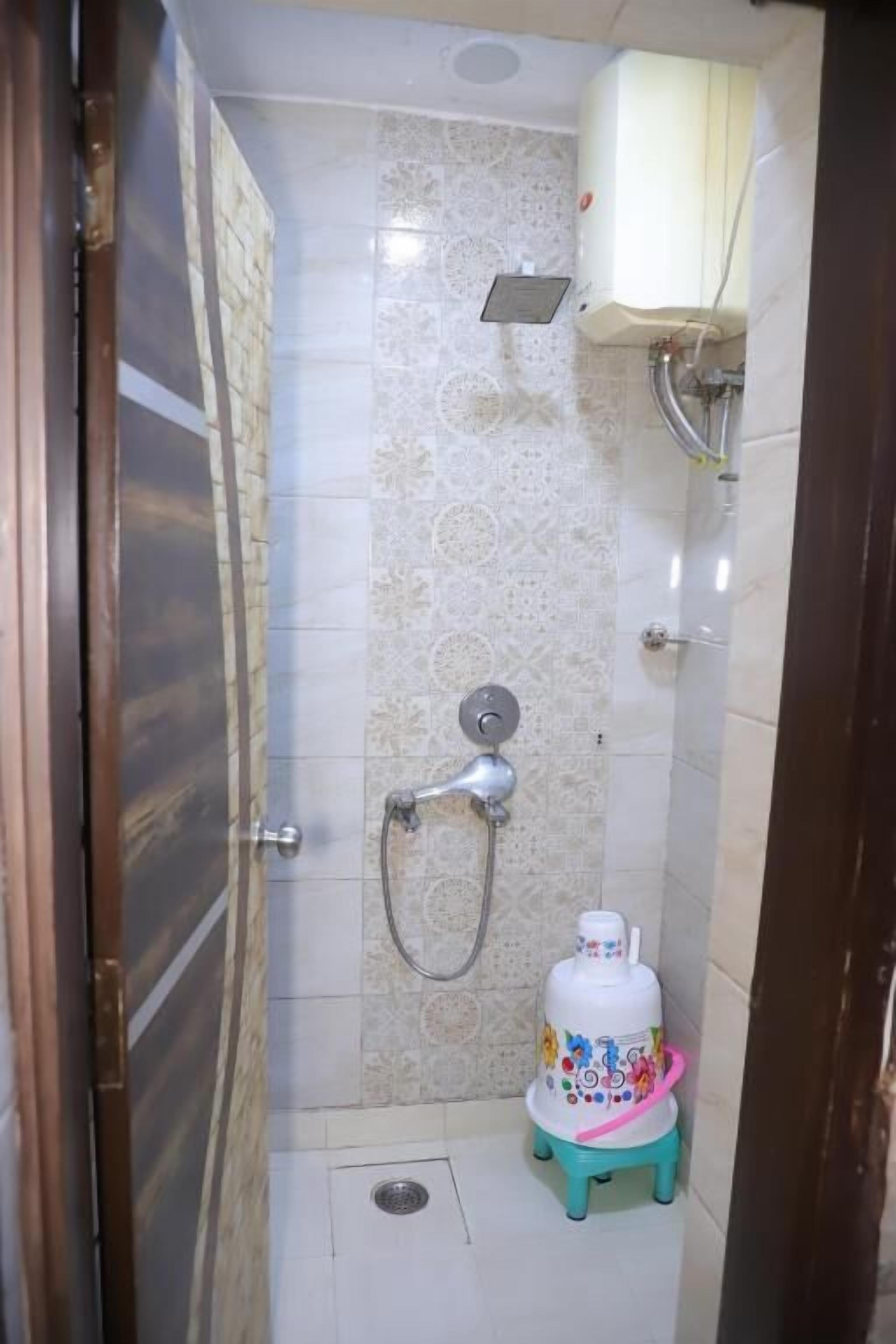 Une salle de bain équipée d’une douche, de toilettes et d’un distributeur d’eau.